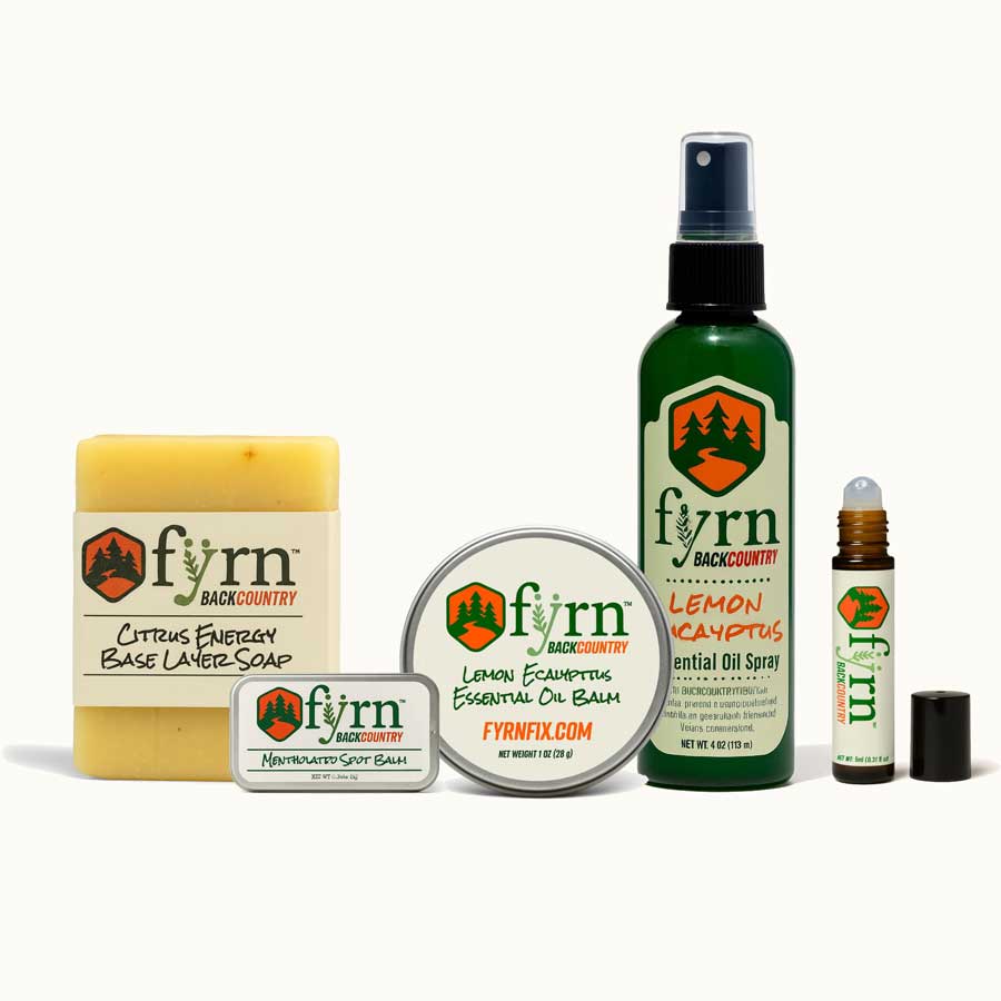 Collection of fyrn Backcountry products including soap, balm, oil spray, and essential oil bottle on a white background.