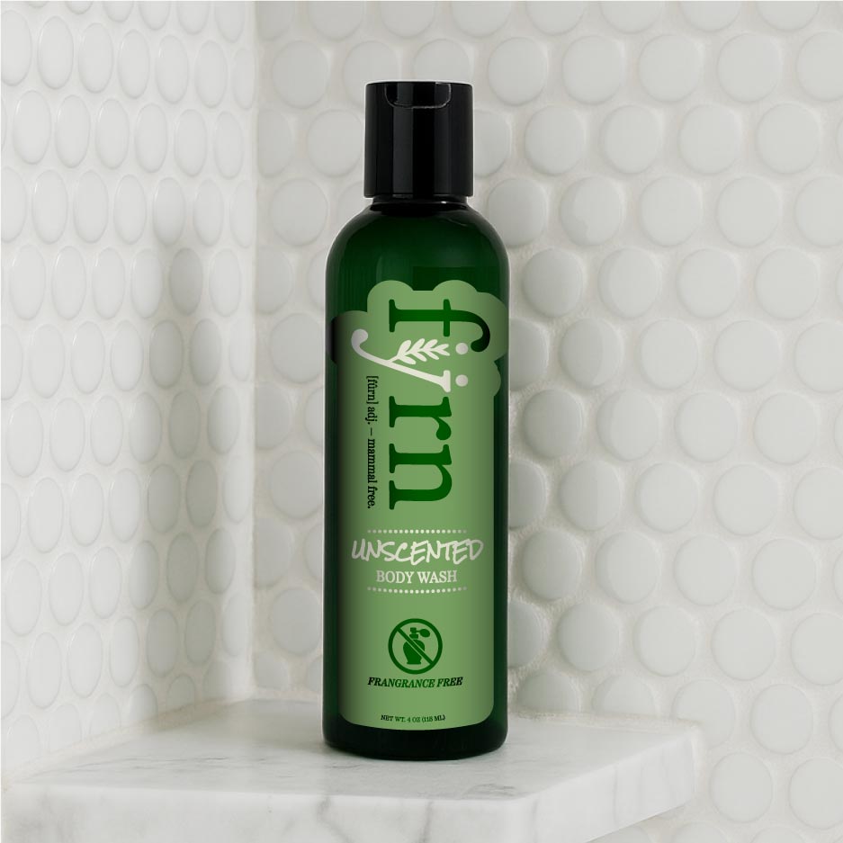 Green bottle of Alpha-gal-friendly unscented body wash on a textured white background