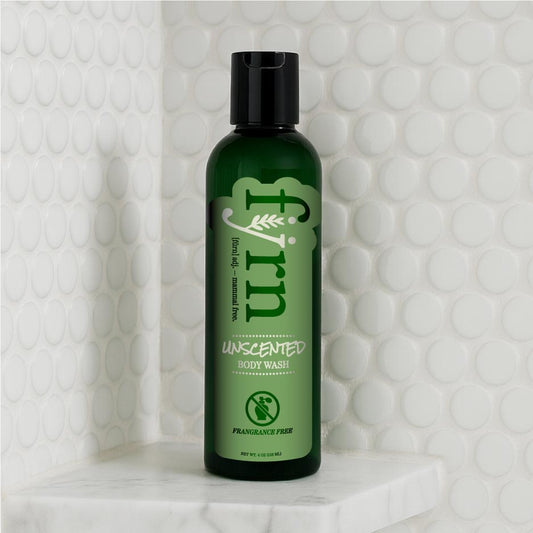 Green bottle of Alpha-gal-friendly unscented body wash on a textured white background