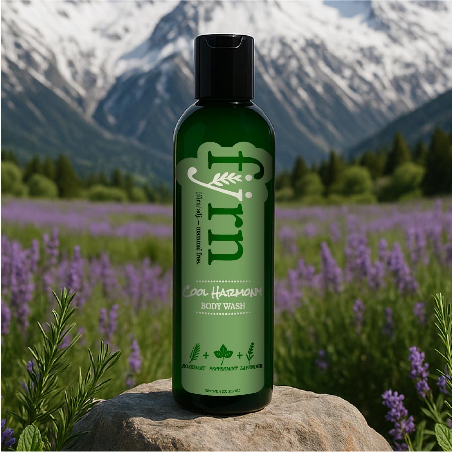 Green bottle of 'furn' body wash on a rock with a mountain and lavender field background