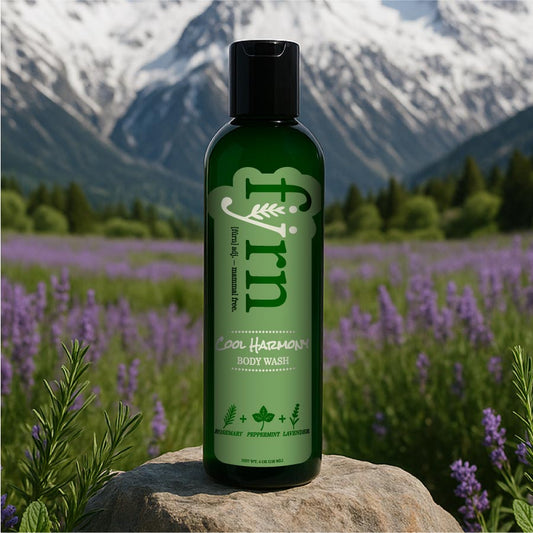 Green bottle of 'furn' body wash on a rock with a mountain and lavender field background