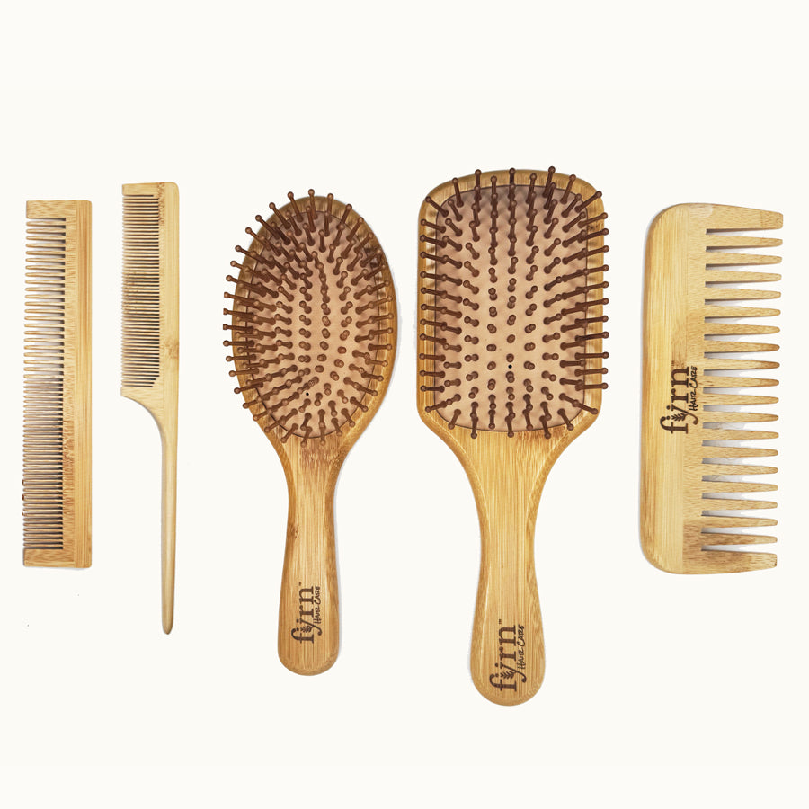 Set of five wooden hairbrushes and combs on a white background