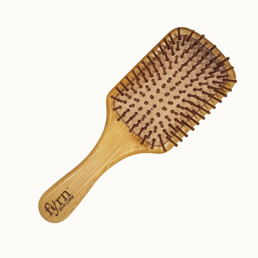 Wooden hairbrush with a natural handle and bristle head on a white background