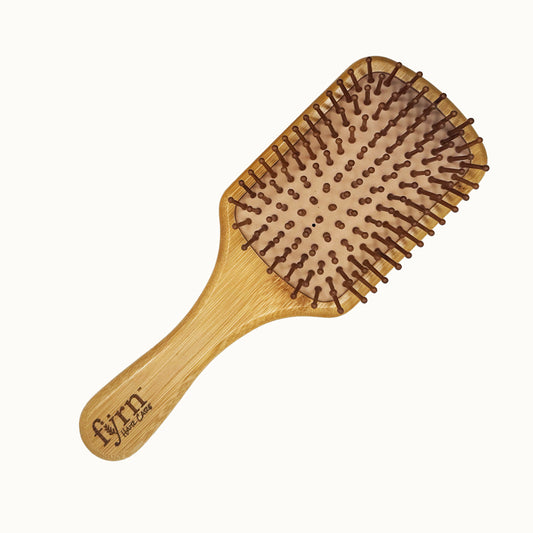 Wooden hairbrush with a natural handle and bristle head on a white background