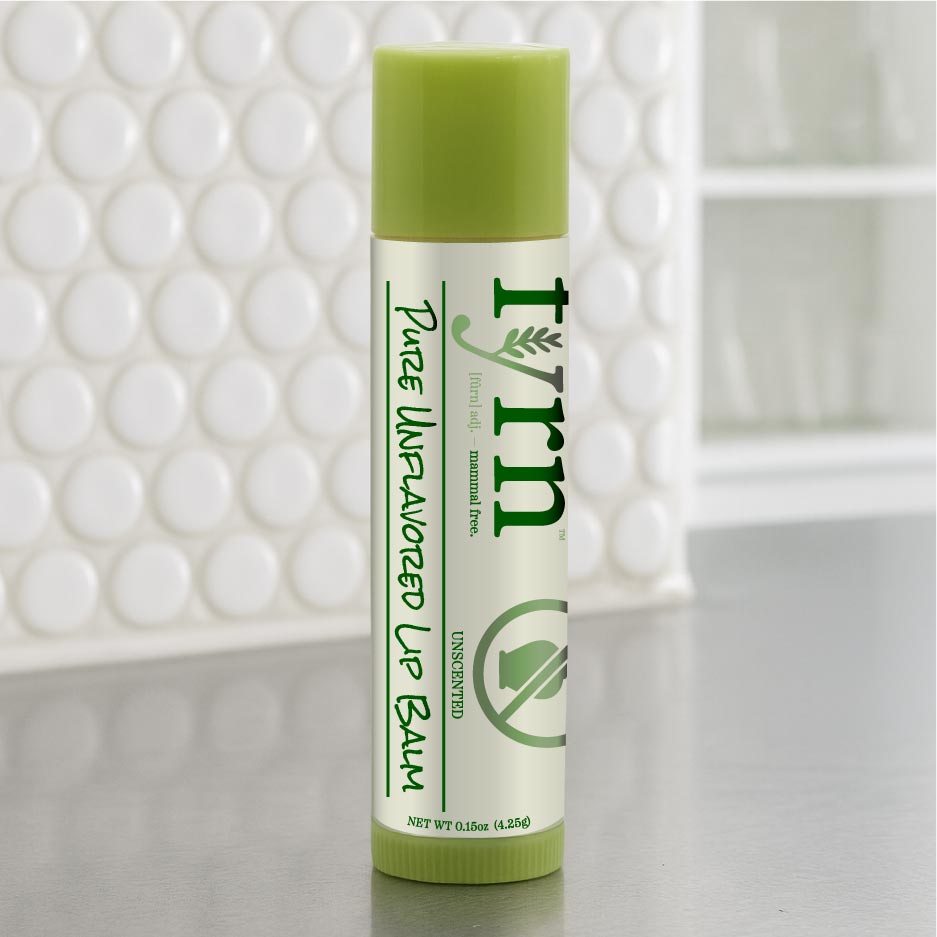 Green lip balm with white label on a neutral background