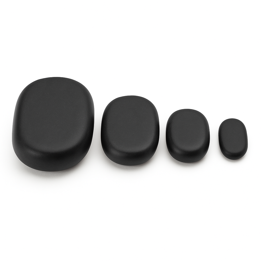 Set of four black stones of varying sizes on a white background