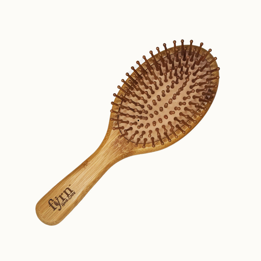 Wooden hairbrush with a handle on a white background