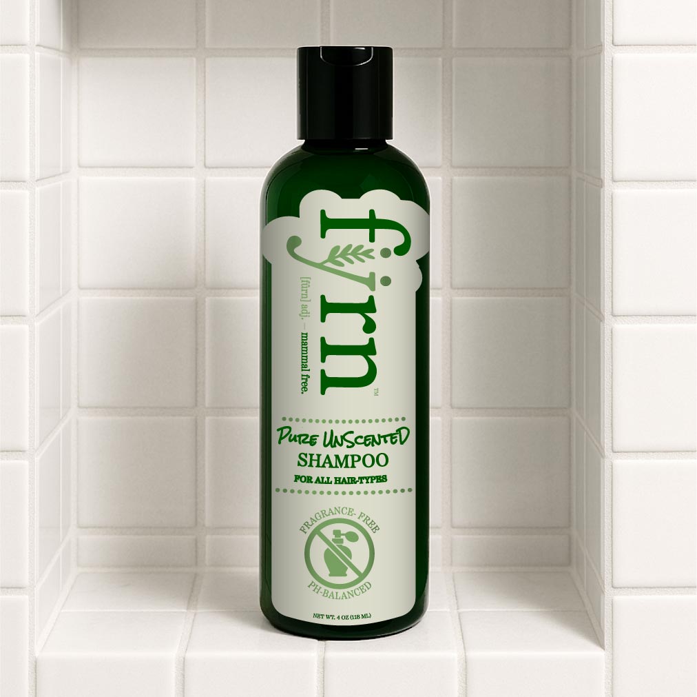 Green shampoo bottle labeled 'fyrn' on a tiled bathroom shelf