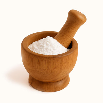 Wooden mortar and pestle with white powder on a white background