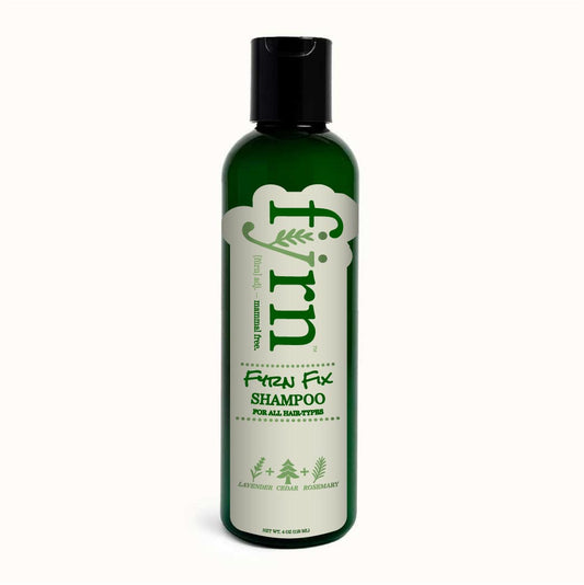 Green shampoo bottle with black cap on a white background