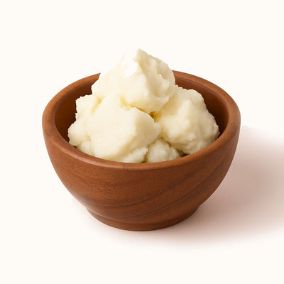 Wooden bowl filled shea butter on a white background